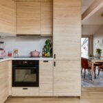 A kitchen with a stove top oven next to a dining room table