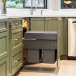 Modern kitchen with green cabinets and custom garbage pull-out