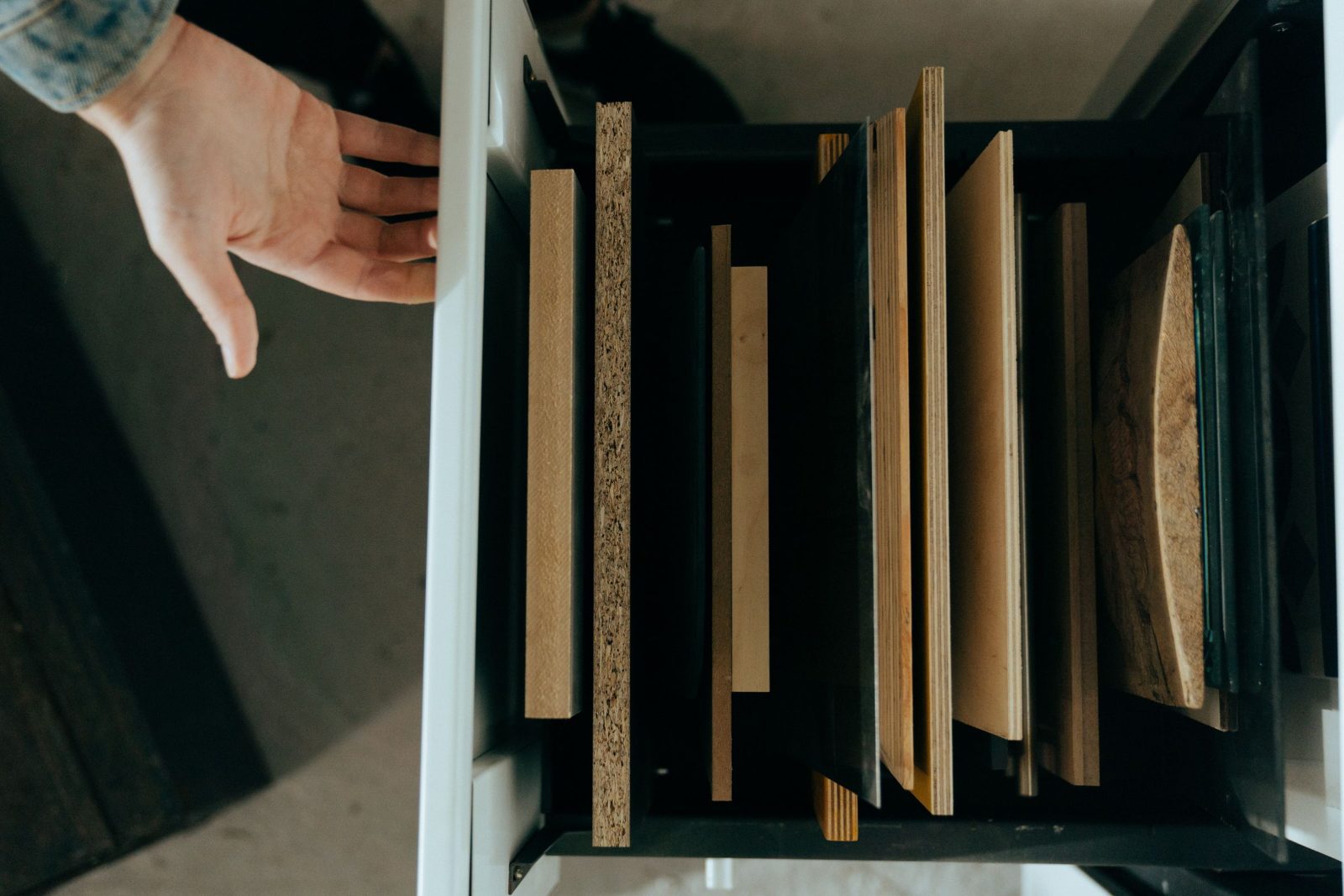 Drawer of cabinet box material samples showing particleboard, plywood and wood panel edges