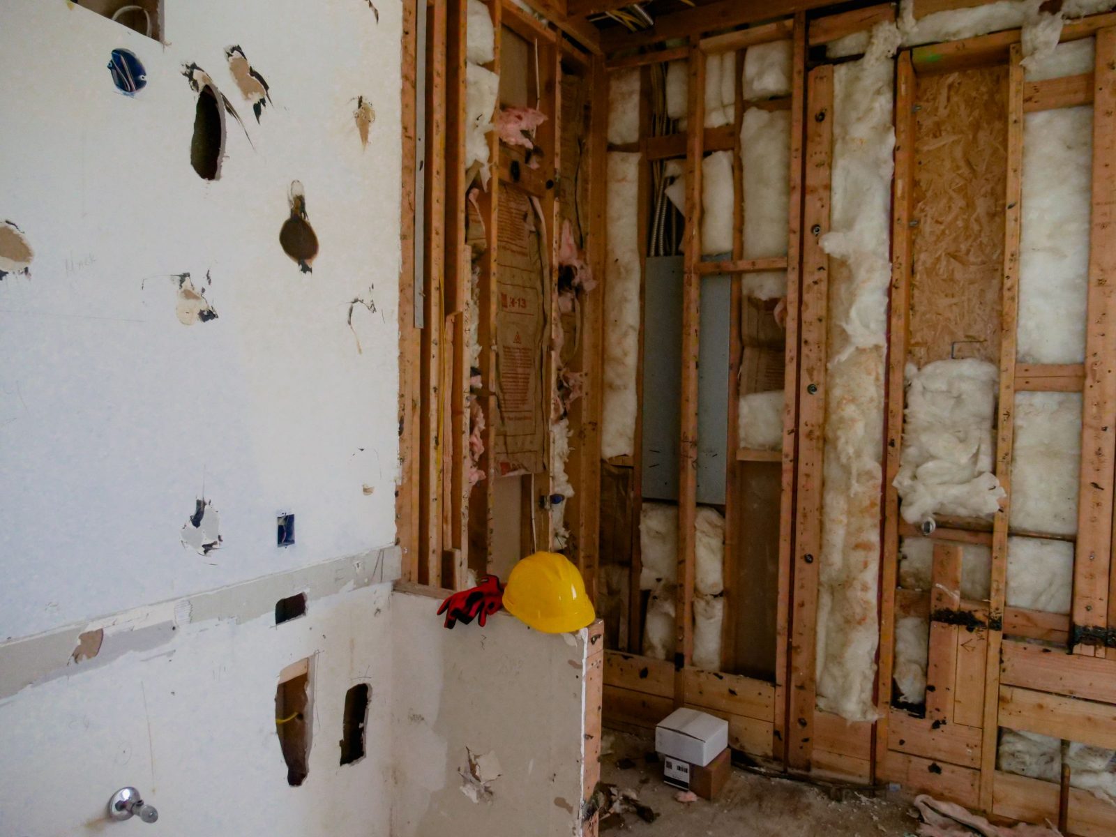 Bathroom wall opened to the studs, the stage where blocking goes in behind a floating vanity
