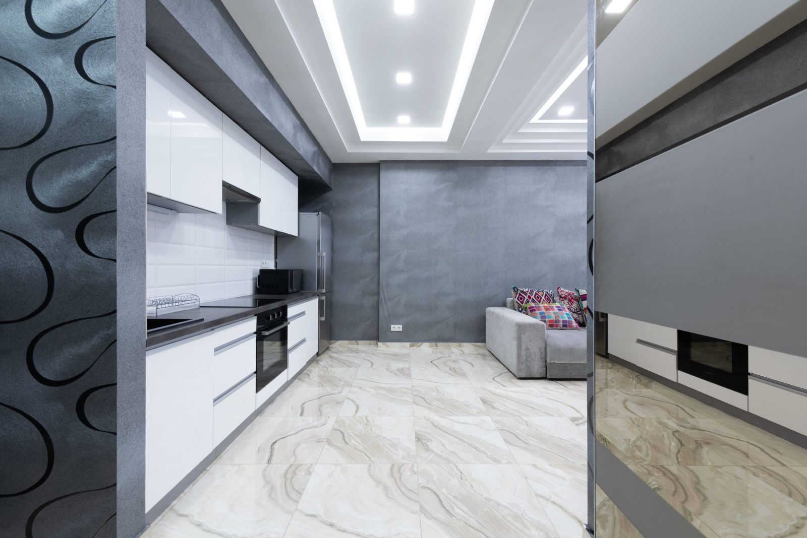 Narrow condo kitchen with white gloss upper cabinets running beneath a dropped ceiling bulkhead