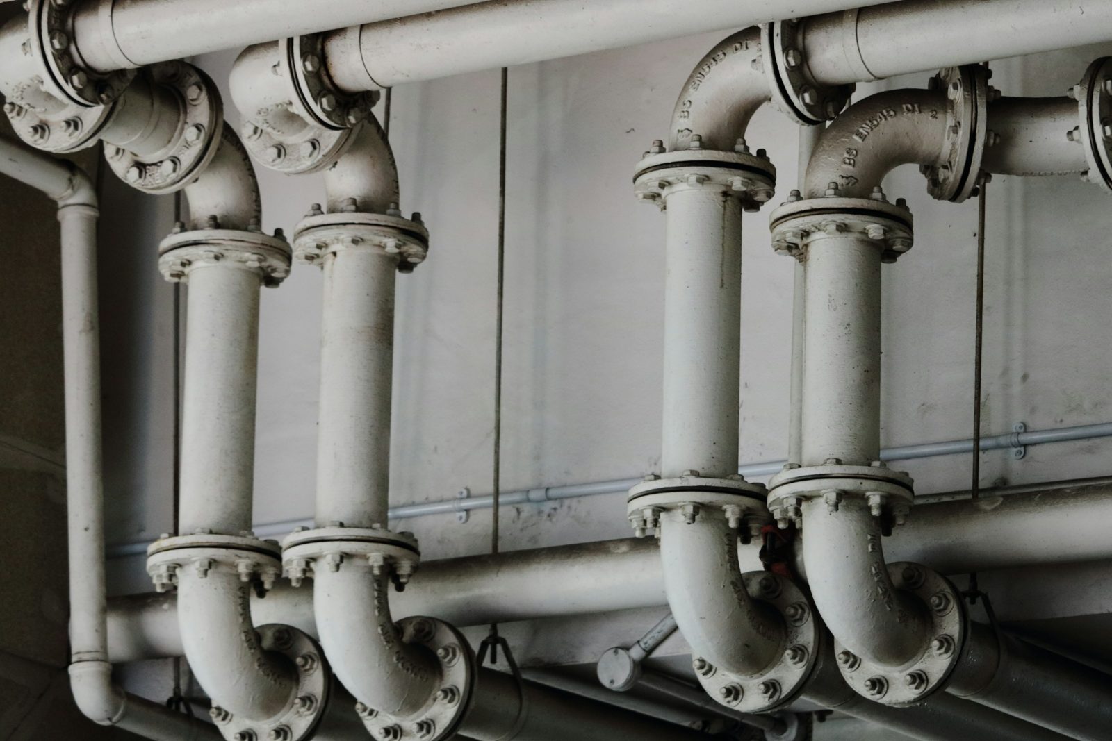 Exposed vertical drain stacks and pipe fittings in a building service space