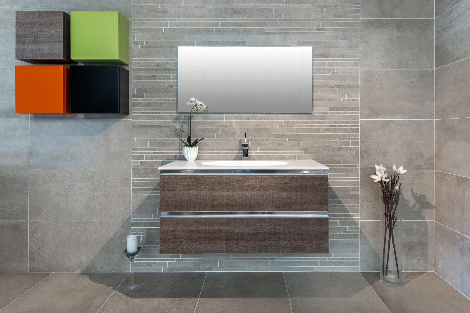 Floating vanity with two drawers in a grey tile bathroom, leaving the floor clear underneath